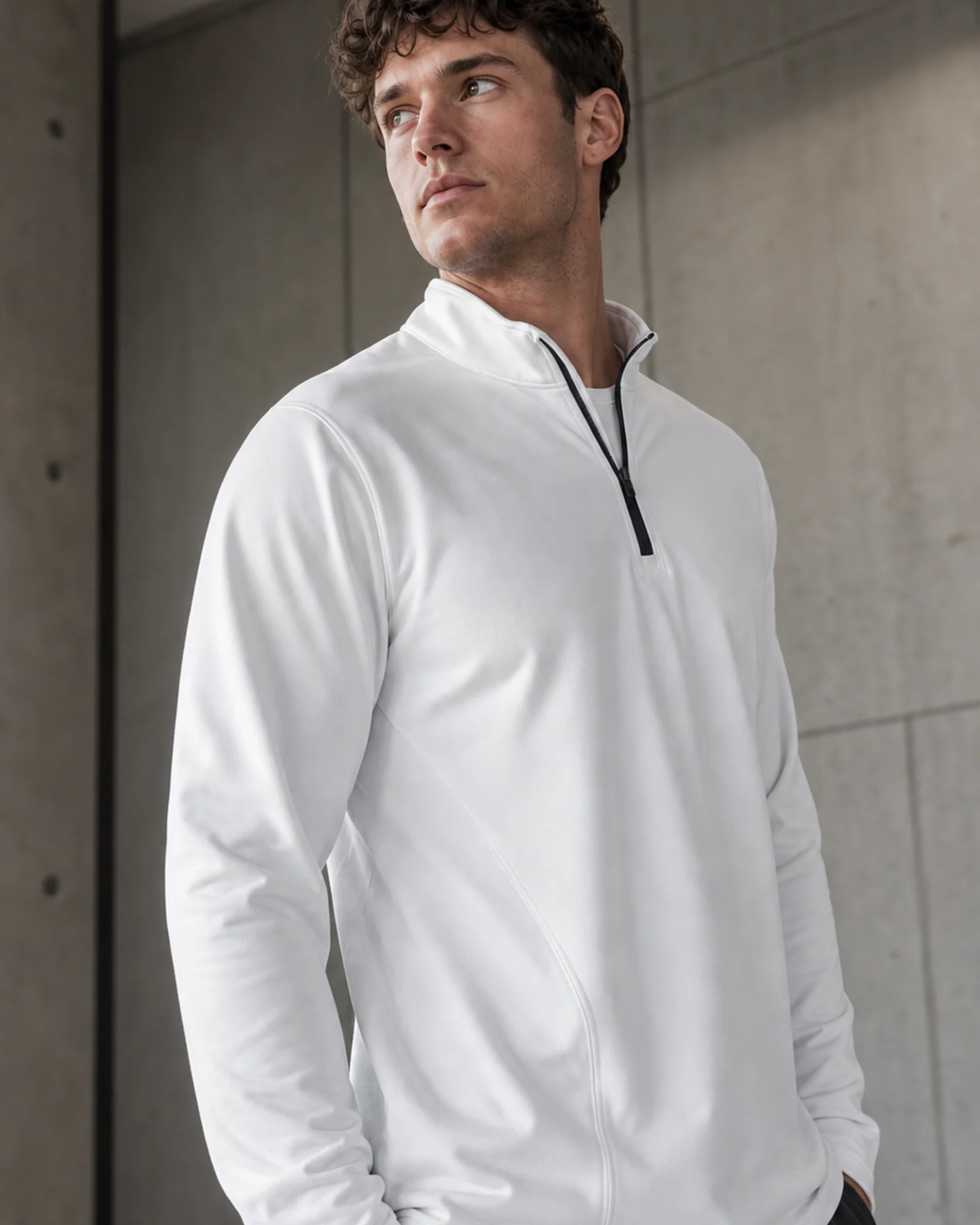 Man wearing a white performance quarter-zip in cool morning light